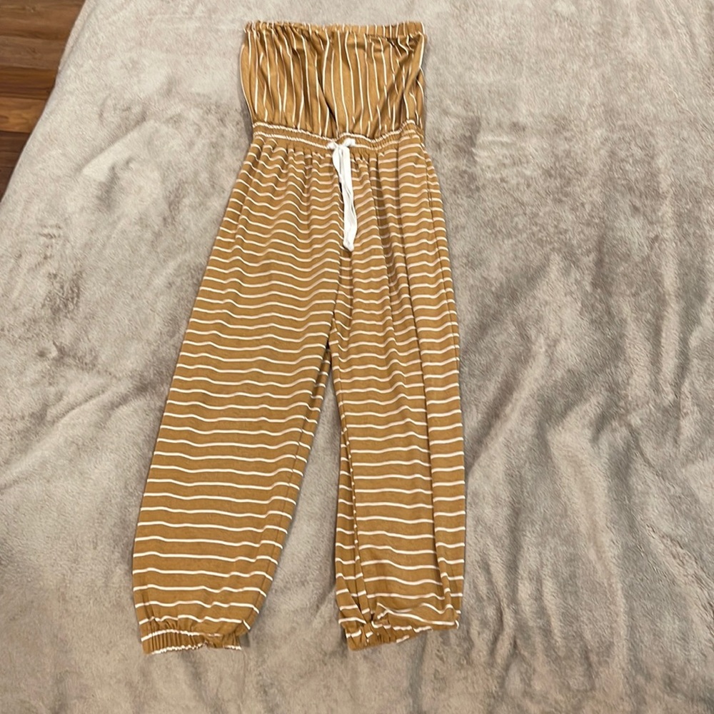 Brown strapless romper with pant legs.